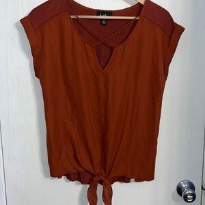 By&By burnt orange top with v neck and x pattern on the front with a tie